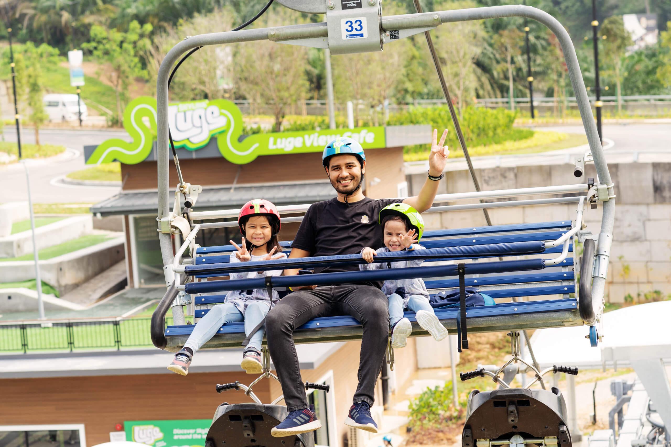 A father and his two kids rides the chairlift at Skyline Luge Kuala Lumpur.