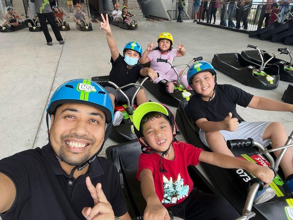A family takes a selfie in their Luge carts ready to ride down the tracks.