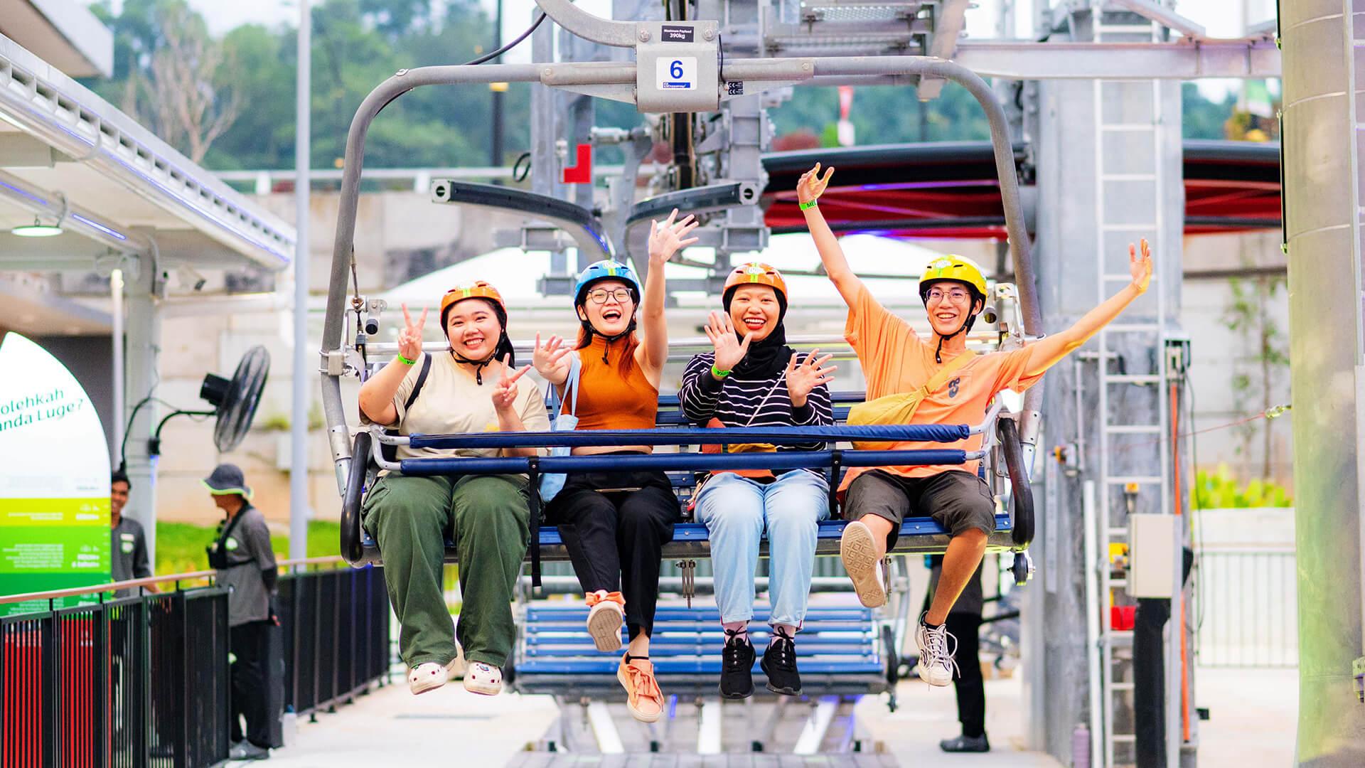 Four friends wave and pull the peace sign as they ride the chairlift.