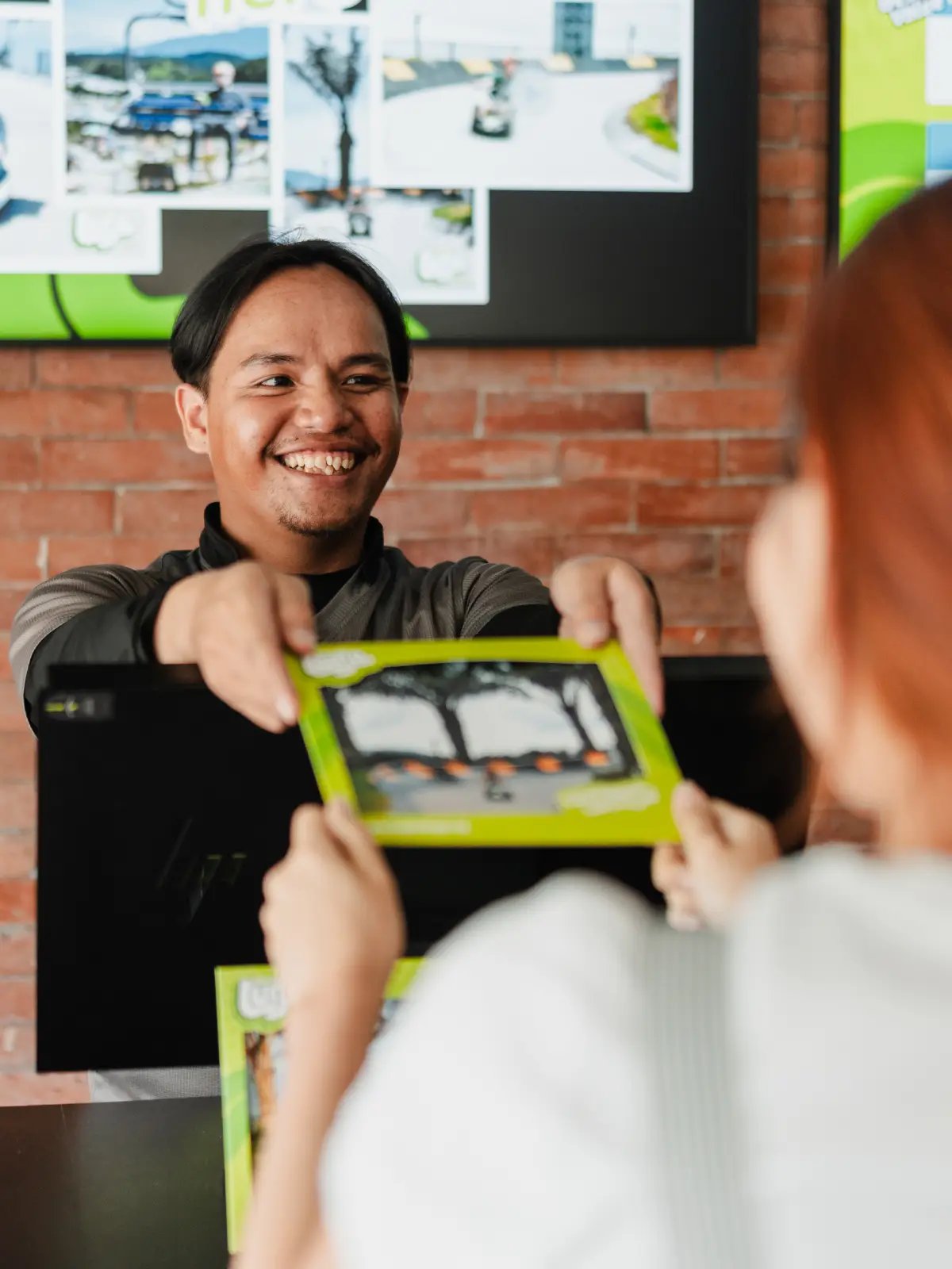 Skyline Luge Kuala Lumpur A Counter staff handing a printed memento to the Guest