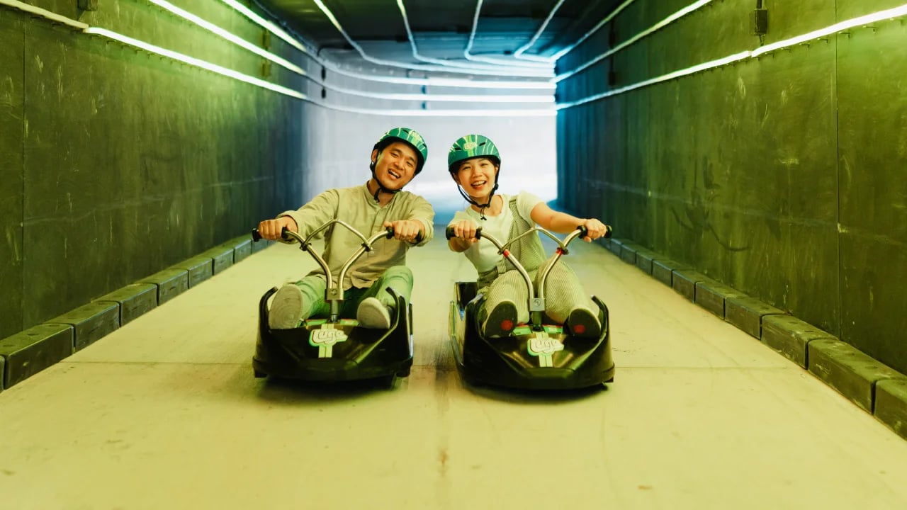 Skyline Luge Kuala Lumpur - A couple riding the Luge carts in the tunnel smiling