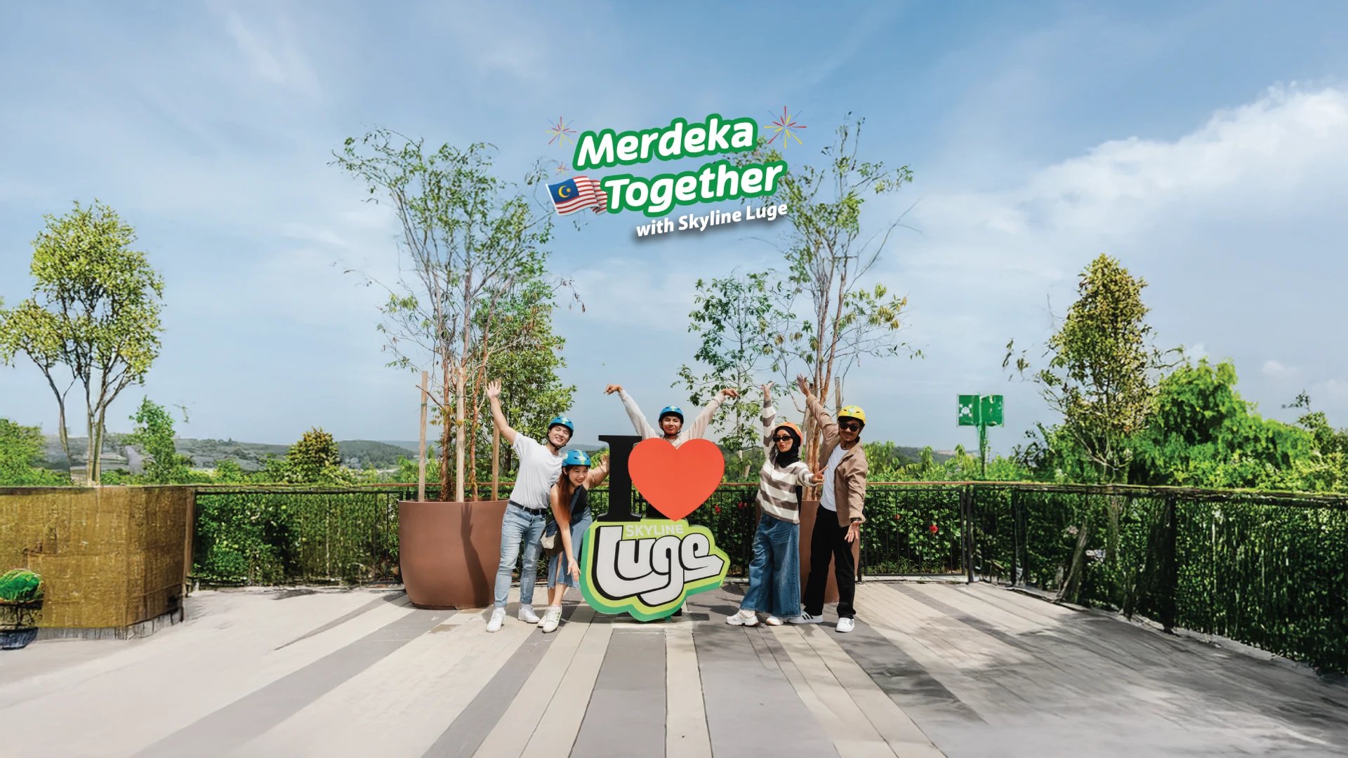 Skyline Luge Kuala Lumpur Merdeka Together Hero Banner - A group of friends posing next to I Heart Luge at the top area after their Skyride.