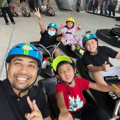 A family takes a selfie in their Luge carts ready to ride down the tracks.
