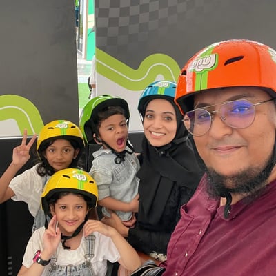 A group family photo with parents and kids all ready to go Luging.
