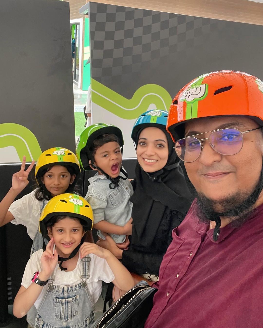 A group family photo with parents and kids all ready to go Luging.