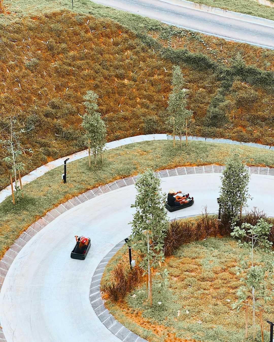 An aerial view of people Luging round a corner.