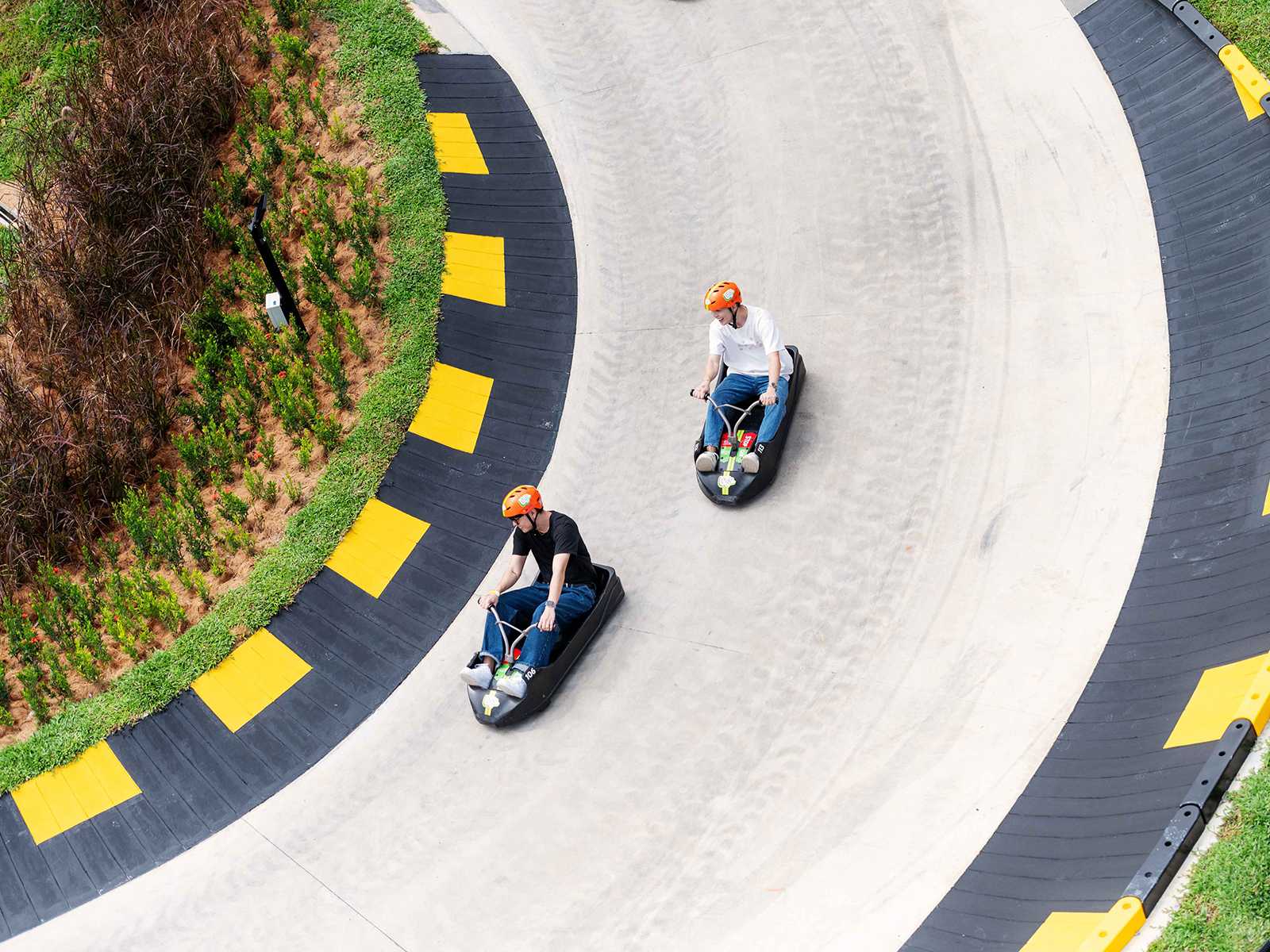 Two people on a luge track.